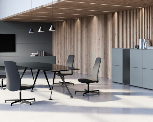 Moderner Konferenzraum mit einem schwarzen Tisch, fünf Stühlen mit hoher Rückenlehne, einem Fernseher an der Wand, minimalistischen Regalen und einer Holzlattenverkleidung, alles in einem hellen Raum mit polierten Böden und Pendelleuchten.